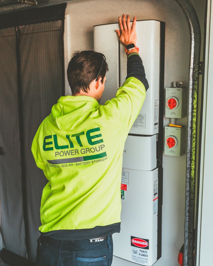 services-04 Technician installing a solar inverter and battery system in New South Wales.
