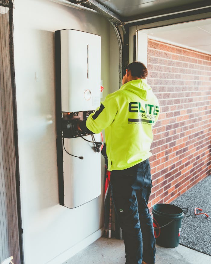 about-us-02 Electrician working on a solar inverter installation inside a garage in New South Wales, Australia.